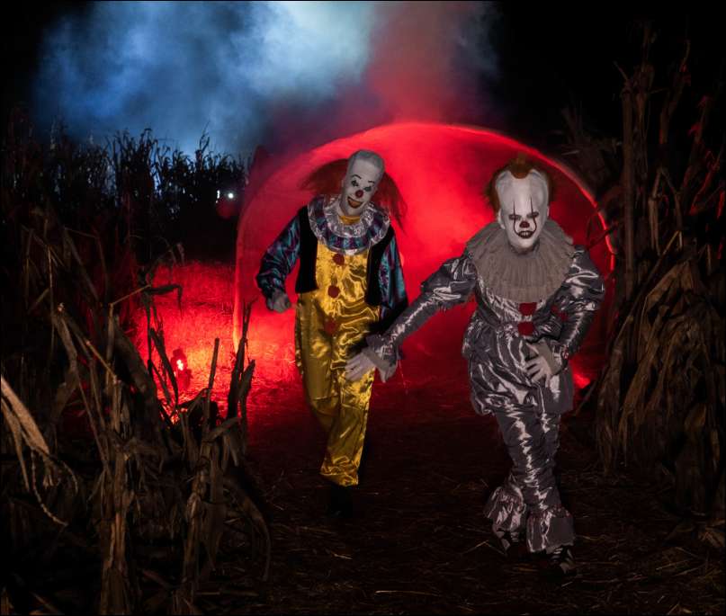 Zwei Horror-Clowns tanzen beim Horrorlabyrinth durch das Maislabyrinth Liederbach